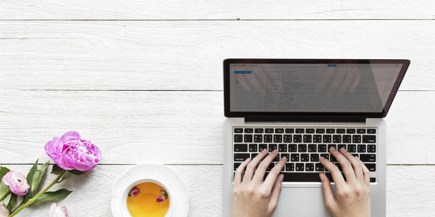 Aerial view of a woman using computer laptop working and hot tea drink